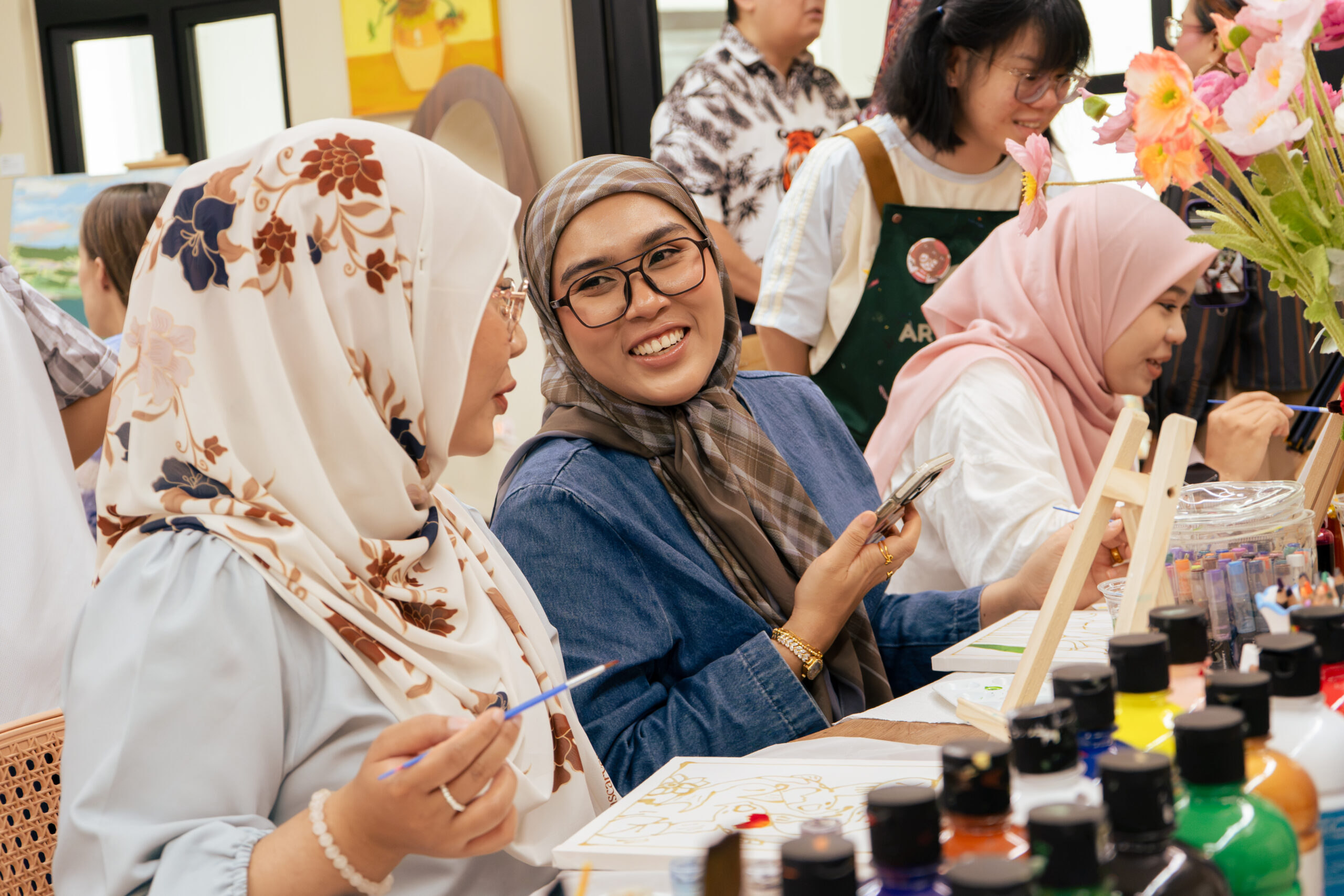 Friends smiling and creating art together at ArtRoots Studio