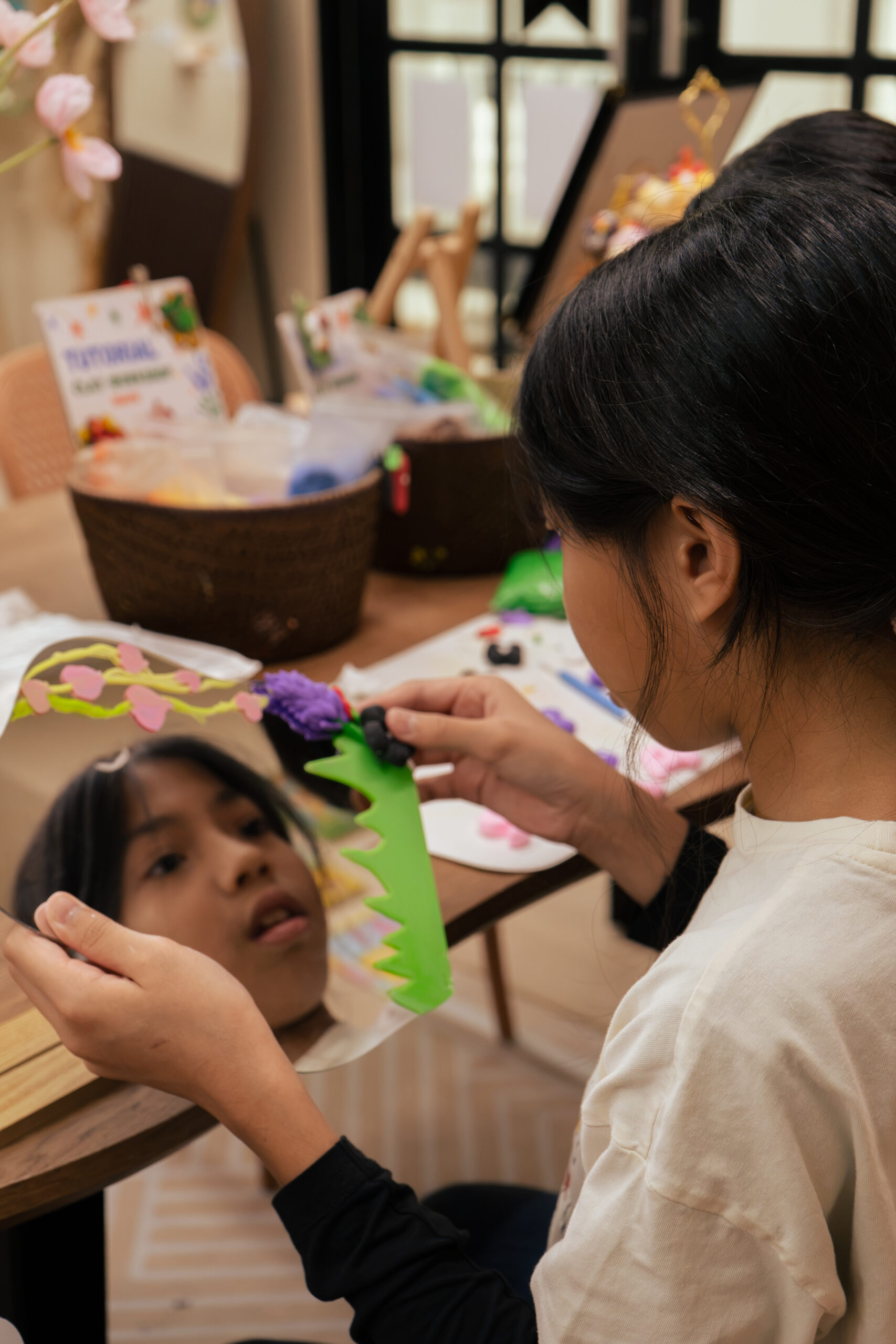 A student decorating a handmade clay mirror at ArtRoots Studio